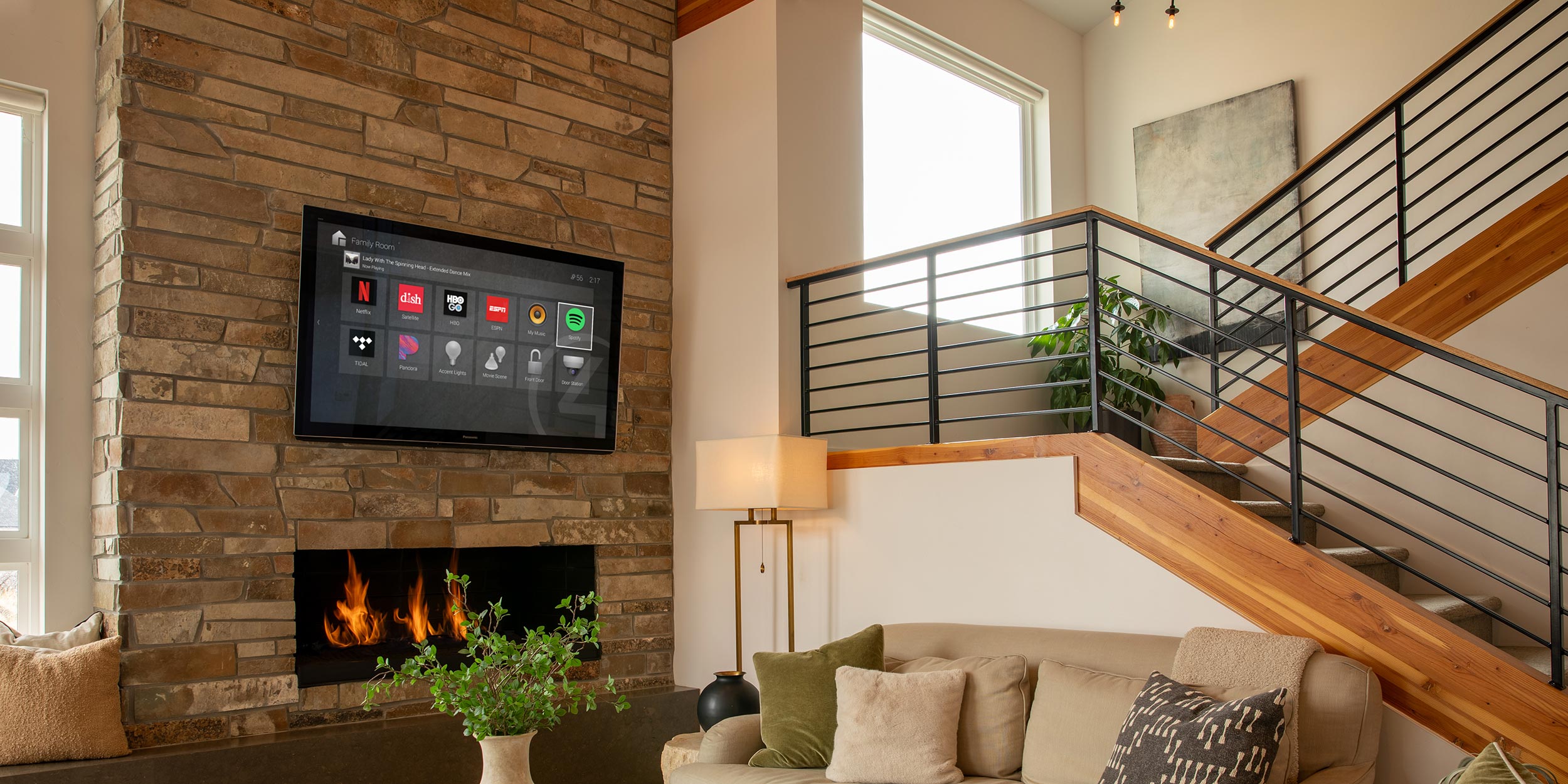 Wall-mounted TV above fireplace displaying smart home controls